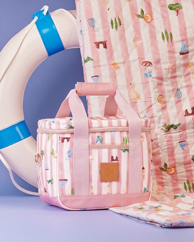 Pink patterned bag with matching blanket and life buoy on a blue background
