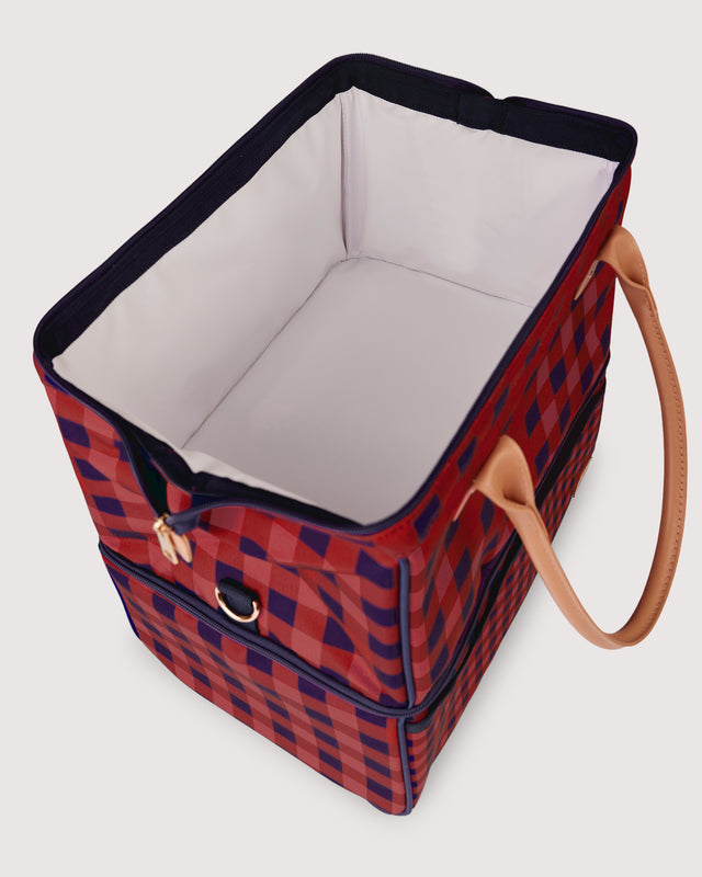 Red and blue checkered bag with a brown handle on a white background