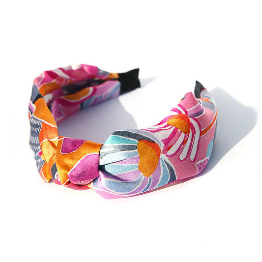 A vibrant, multicolored silk headband displayed on a white background.