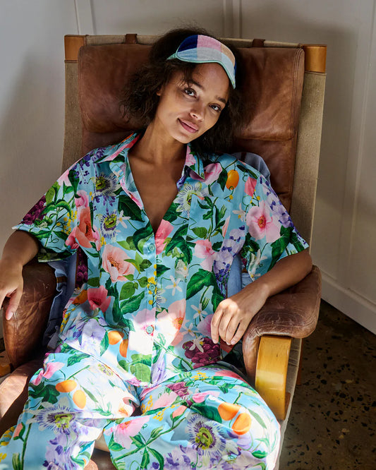 Woman in a floral outfit sitting on a chair indoors
