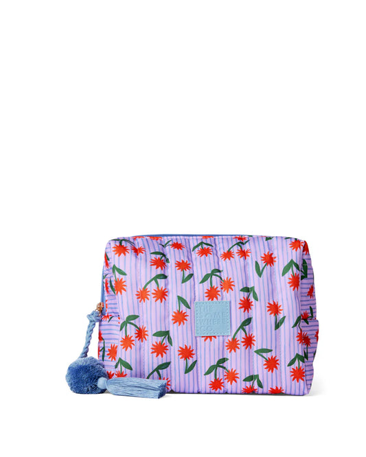 Floral patterned pouch with pom-pom details on a white background