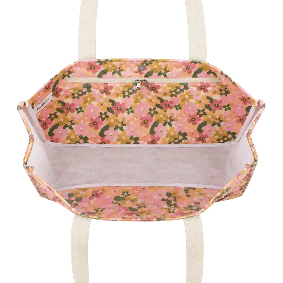 An open tote bag with a pink floral print lining and cream-colored shoulder straps, shown against a plain white background.