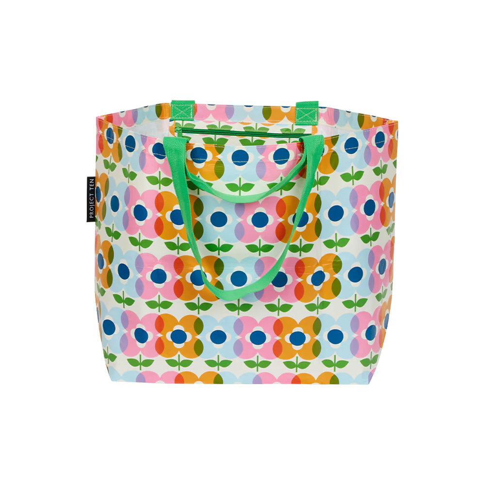 Colorful pink, orange and blue floral-patterned bag with green handles on a white background