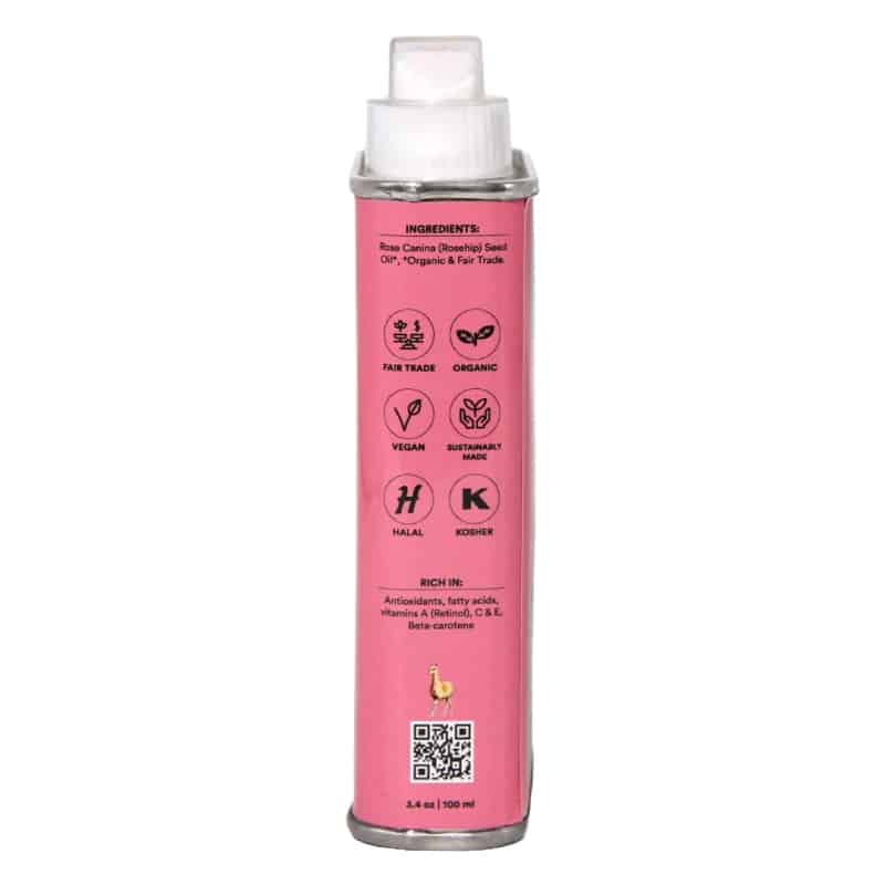 A pink canister of rosehip oil, featuring a white nozzle cap and printed product details on the front.