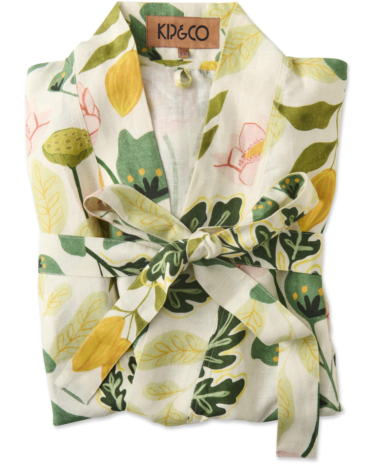 A folded white cotton robe with a tie belt, featuring a vibrant green, yellow, and pink botanical leaf print. A brown paper brand label reading 'K&CO' is visible at the collar.