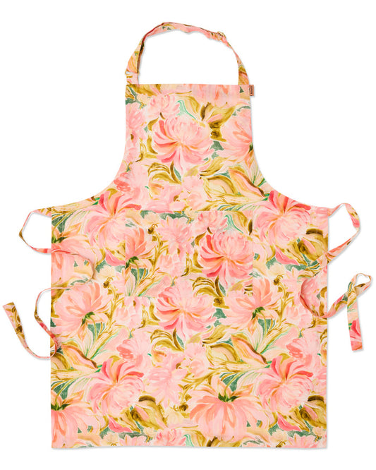 A floral apron with a pink and peach rose pattern, featuring green leaves and yellow accents, displayed flat against a white background.