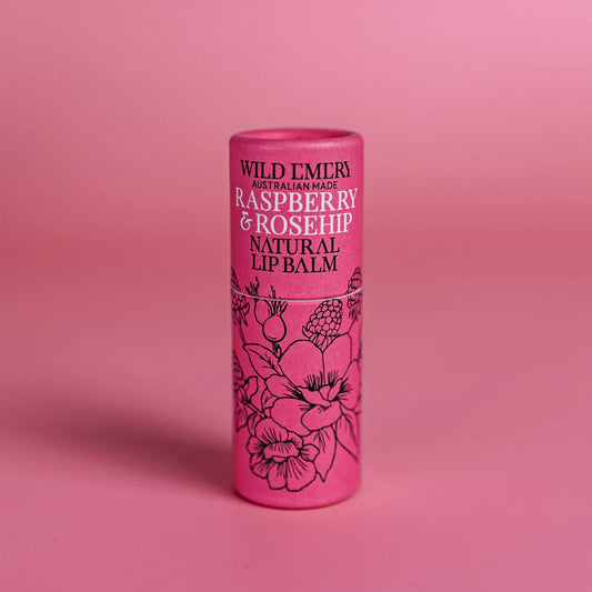 Pink lip balm container with floral design and text on a pink background. Wild Emery Branding. Raspberry and Rosehip Flavour.