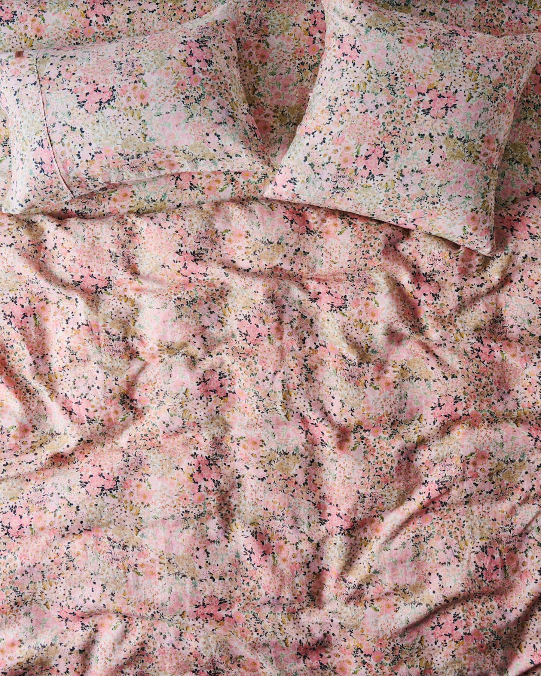 A fitted sheet with a floral pattern in shades of pink and green.